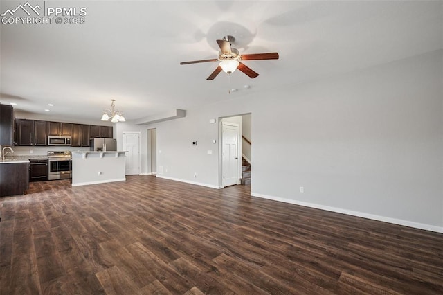 7318 Dutch Loop, Colorado Springs, CO 80925 - unfurnished living room featuring a sink, ceiling fan with notable chandelier, stairs, baseboards, and dark wood-style floors