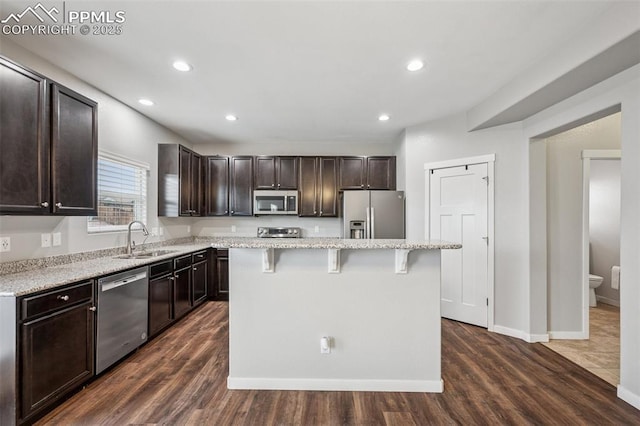 7318 Dutch Loop, Colorado Springs, CO 80925 - kitchen featuring dark brown cabinetry, appliances with stainless steel finishes, a sink, a kitchen breakfast bar, and a kitchen island