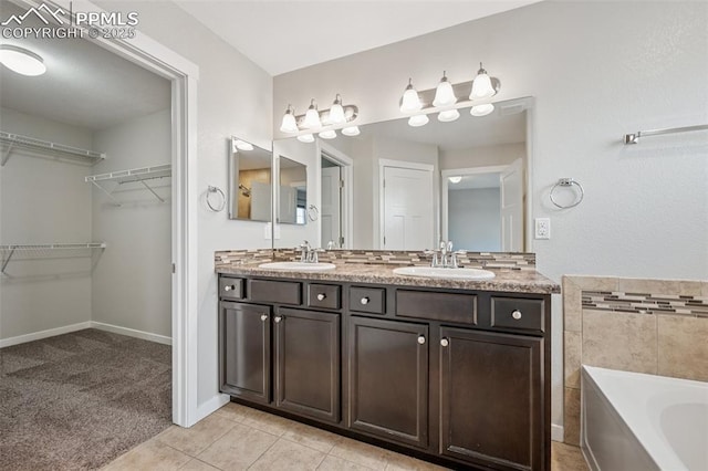 7318 Dutch Loop, Colorado Springs, CO 80925 - bathroom with double vanity, a walk in closet, a sink, and a garden tub