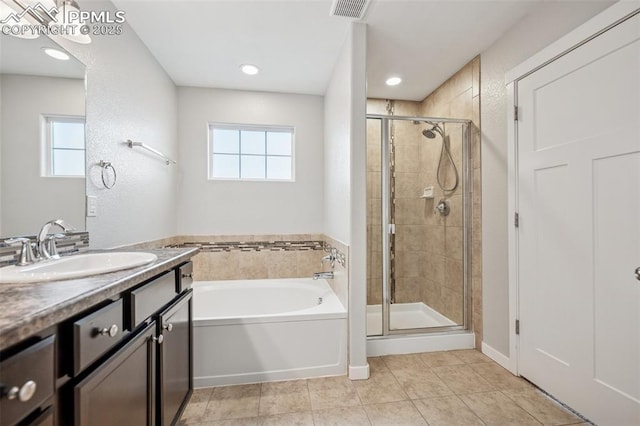 7318 Dutch Loop, Colorado Springs, CO 80925 - full bath with vanity, a healthy amount of sunlight, a bath, and a stall shower