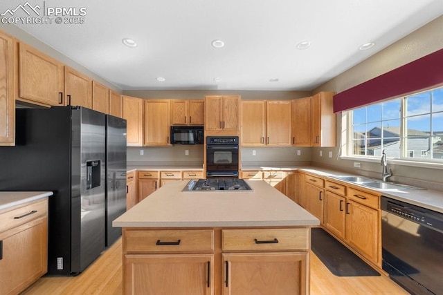 9089 Royal Melbourne Cir, Peyton, CO 80831 - kitchen featuring a sink, a kitchen island, light wood-style floors, and black appliances