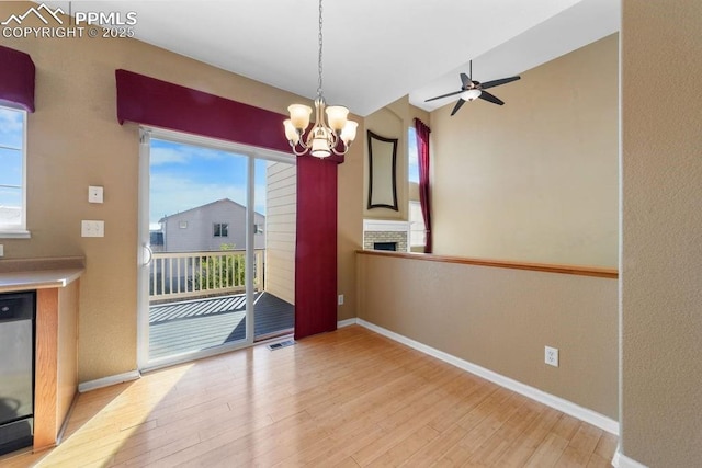 9089 Royal Melbourne Cir, Peyton, CO 80831 - unfurnished dining area with baseboards, ceiling fan with notable chandelier, wood finished floors, and a wealth of natural light