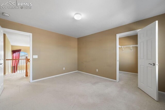 9089 Royal Melbourne Cir, Peyton, CO 80831 - unfurnished bedroom featuring baseboards, light carpet, a closet, and a spacious closet