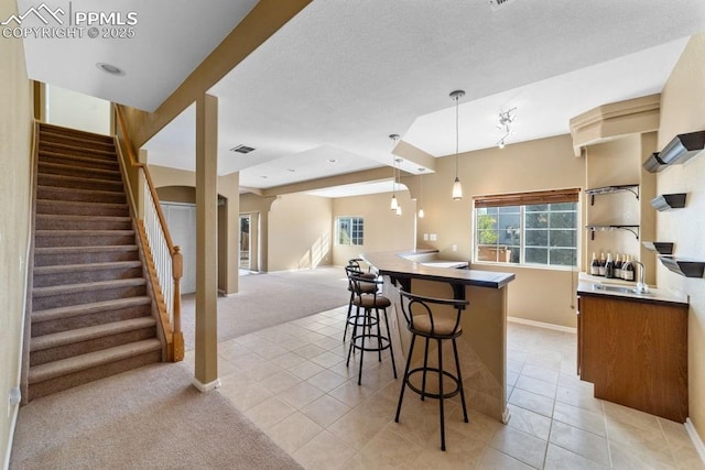 9089 Royal Melbourne Cir, Peyton, CO 80831 - kitchen with a breakfast bar, dark countertops, baseboards, light colored carpet, and a sink