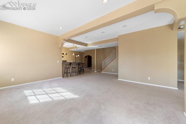 9089 Royal Melbourne Cir, Peyton, CO 80831 - unfurnished living room with carpet floors, arched walkways, baseboards, and recessed lighting