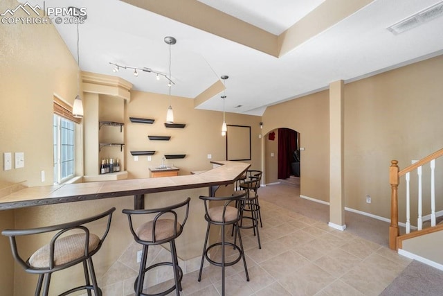 9089 Royal Melbourne Cir, Peyton, CO 80831 - kitchen with tile patterned flooring, a breakfast bar area, arched walkways, tile countertops, and visible vents