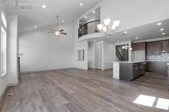 kitchen with dark brown cabinets, light countertops, dark wood finished floors, recessed lighting, and open floor plan