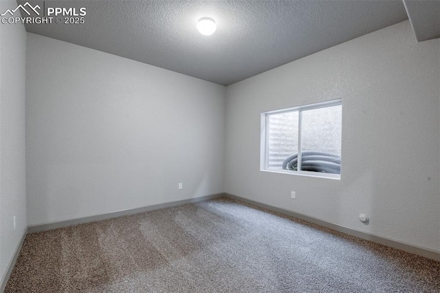 unfurnished room with carpet floors, a textured ceiling, and baseboards