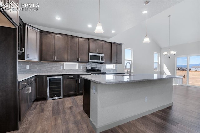 kitchen featuring decorative backsplash, beverage cooler, a sink, a notable chandelier, and stainless steel appliances