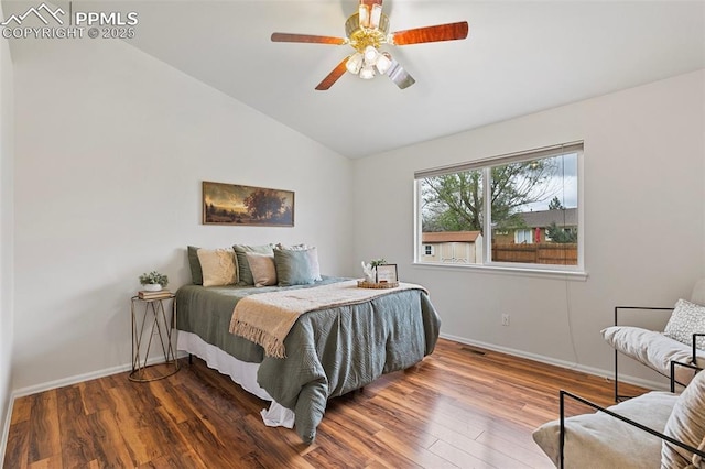 bedroom with vaulted ceiling, baseboards, wood finished floors, and a ceiling fan