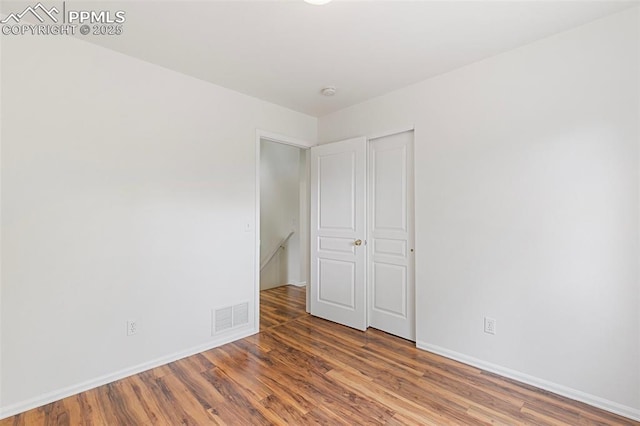 unfurnished bedroom featuring wood finished floors and baseboards