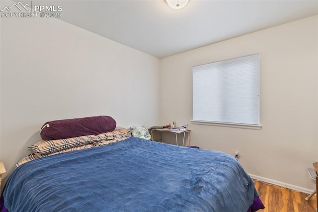 bedroom with wood finished floors and baseboards