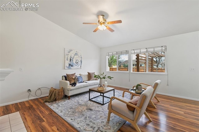 living room featuring vaulted ceiling, a ceiling fan, baseboards, and wood finished floors