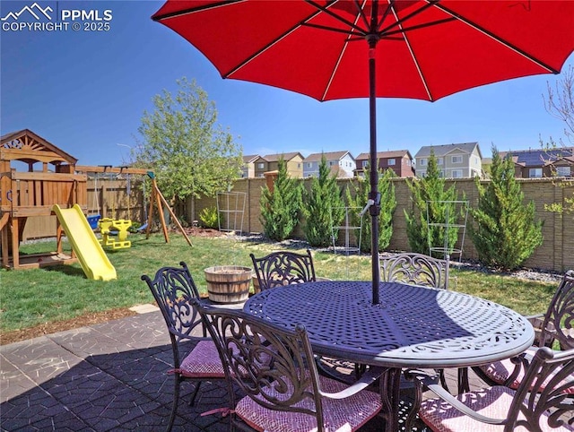 6996 Mustang Rim Dr, Colorado Springs, CO 80923 - view of patio with a playground, outdoor dining area, a fenced backyard, and a residential view