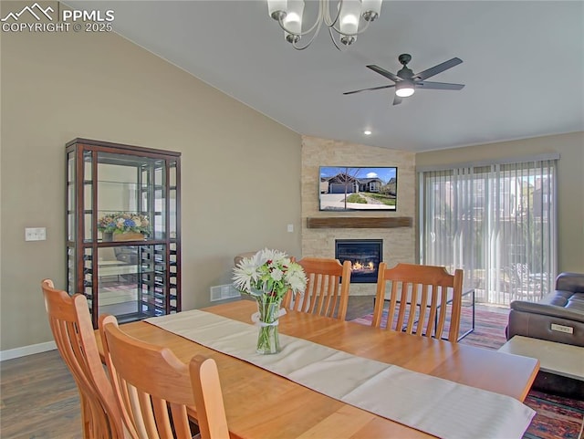 6996 Mustang Rim Dr, Colorado Springs, CO 80923 - dining room featuring a fireplace, ceiling fan with notable chandelier, wood finished floors, lofted ceiling, and visible vents