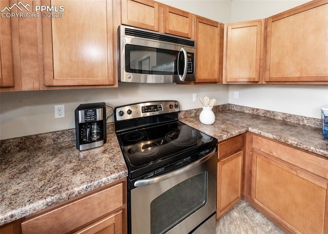 kitchen featuring appliances with stainless steel finishes and stone counters