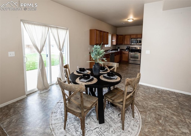 dining space featuring baseboards and dark floors