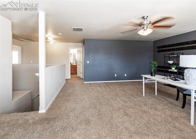 carpeted home office with baseboards and a ceiling fan