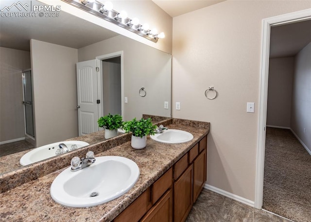 bathroom featuring double vanity, a shower stall, and a sink