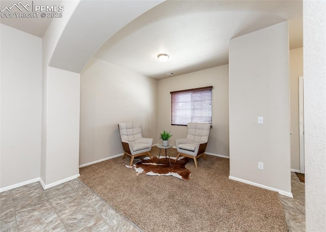 sitting room featuring baseboards and carpet