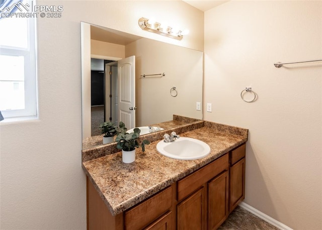 bathroom with baseboards, a wealth of natural light, and vanity