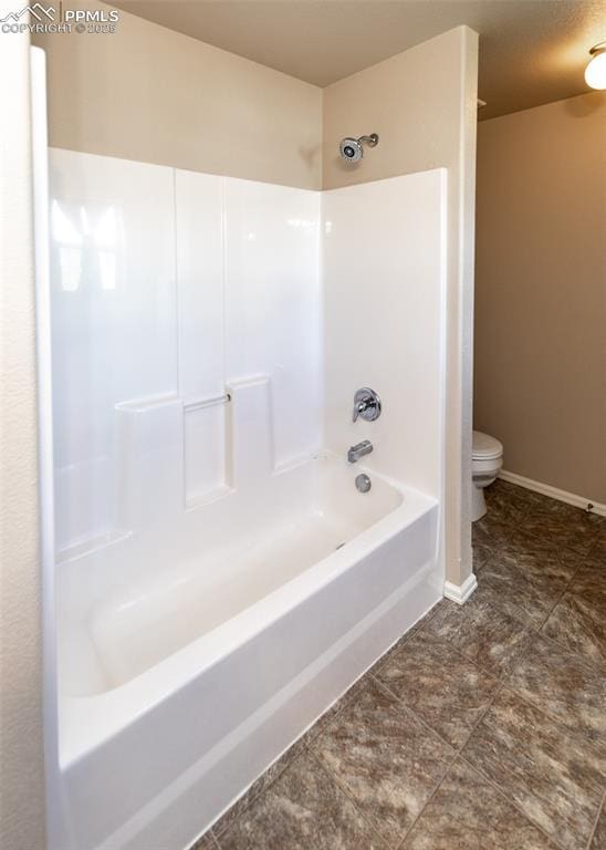 full bath featuring bathing tub / shower combination, baseboards, and toilet