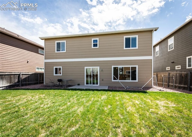 rear view of property with a lawn and a fenced backyard