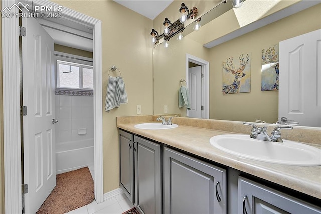 full bath with a sink, tile patterned floors, a tub to relax in, and double vanity