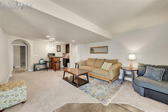 living area with light colored carpet, arched walkways, baseboards, and recessed lighting
