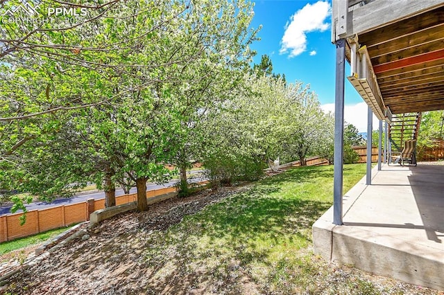 view of yard featuring fence, a patio, and stairway