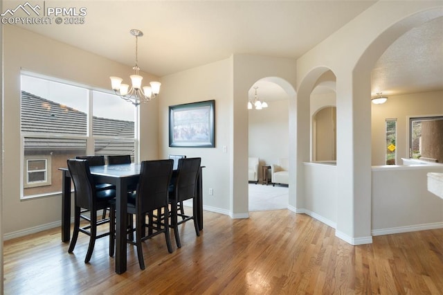 2532 Sierra Oak Dr, Colorado Springs, CO 80919 - dining space with arched walkways, baseboards, an inviting chandelier, and wood finished floors