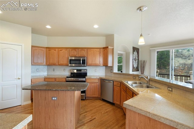 2532 Sierra Oak Dr, Colorado Springs, CO 80919 - kitchen with backsplash, stainless steel appliances, a sink, and light wood-style floors