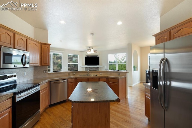 2532 Sierra Oak Dr, Colorado Springs, CO 80919 - kitchen featuring a peninsula, a center island, a sink, a wealth of natural light, and stainless steel appliances