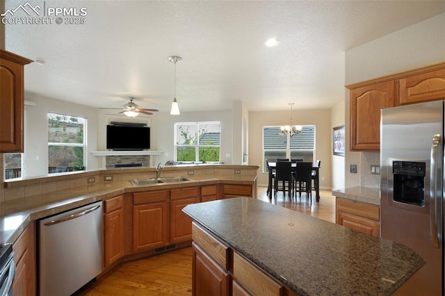 2532 Sierra Oak Dr, Colorado Springs, CO 80919 - kitchen featuring dark countertops, a sink, light wood-style flooring, stainless steel appliances, and a peninsula