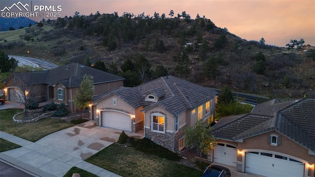 2532 Sierra Oak Dr, Colorado Springs, CO 80919 - view of front of house with an attached garage, concrete driveway, stucco siding, and stone siding