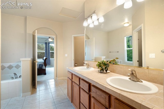 2532 Sierra Oak Dr, Colorado Springs, CO 80919 - ensuite bathroom featuring tile patterned flooring, a sink, double vanity, and a relaxing tiled tub