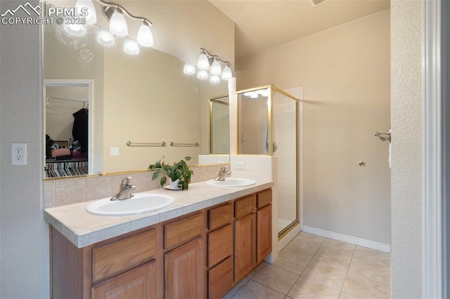 2532 Sierra Oak Dr, Colorado Springs, CO 80919 - full bathroom featuring double vanity, a spacious closet, a shower stall, and a sink