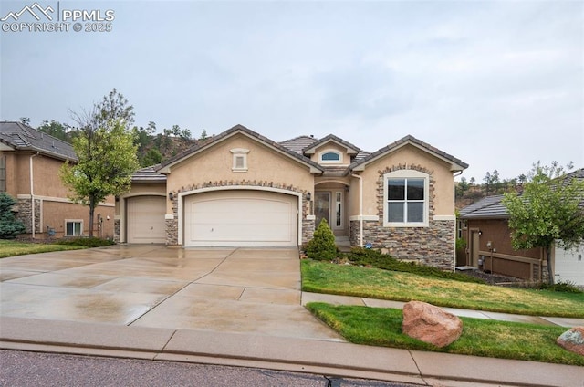 2532 Sierra Oak Dr, Colorado Springs, CO 80919 - view of front facade with a garage, stucco siding, driveway, and stone siding
