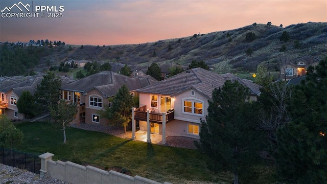 2532 Sierra Oak Dr, Colorado Springs, CO 80919 - exterior space with a deck with mountain view, a tile roof, a front yard, and stucco siding