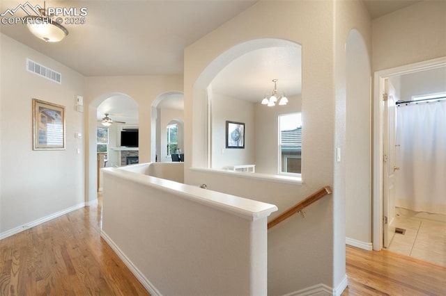 2532 Sierra Oak Dr, Colorado Springs, CO 80919 - corridor featuring arched walkways, baseboards, light wood finished floors, and visible vents