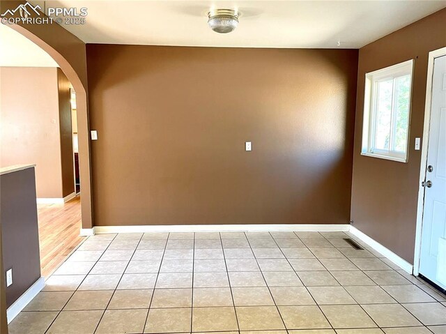 136 Sumac Dr, Colorado Springs, CO 80911 - entrance foyer with arched walkways, baseboards, and light tile patterned flooring