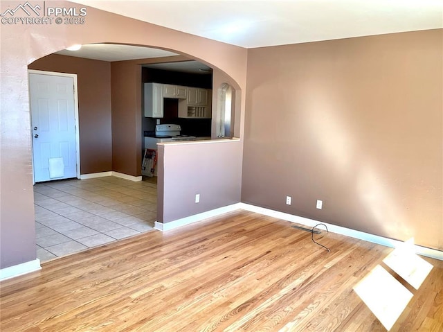 136 Sumac Dr, Colorado Springs, CO 80911 - unfurnished room with light wood-style floors, arched walkways, and baseboards
