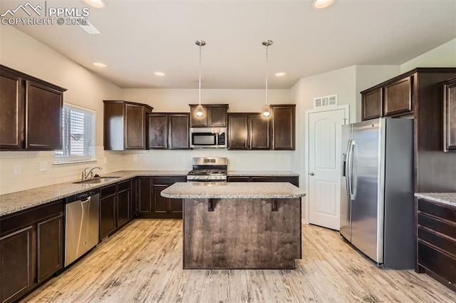 8094 Misty Moon Dr, Colorado Springs, CO 80924 - kitchen featuring visible vents, appliances with stainless steel finishes, dark brown cabinetry, and a center island