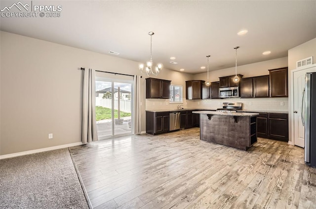 8094 Misty Moon Dr, Colorado Springs, CO 80924 - kitchen featuring dark brown cabinets, a kitchen island, stainless steel appliances, and visible vents