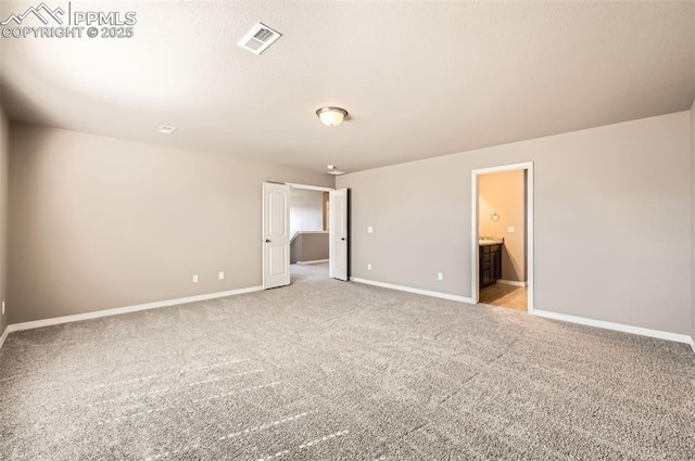 8094 Misty Moon Dr, Colorado Springs, CO 80924 - unfurnished bedroom with baseboards, ensuite bathroom, light colored carpet, and visible vents