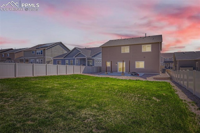 8094 Misty Moon Dr, Colorado Springs, CO 80924 - back of house at dusk with a fenced backyard, a patio area, a yard, and a residential view