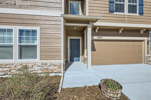 8094 Misty Moon Dr, Colorado Springs, CO 80924 - property entrance with an attached garage, driveway, and stone siding