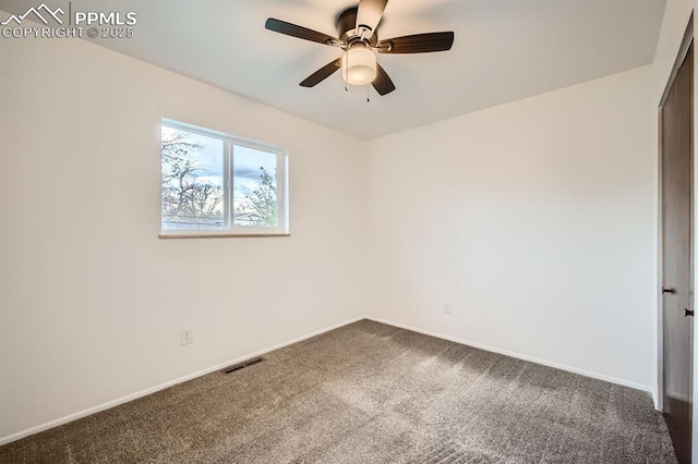 empty room featuring visible vents, a ceiling fan, baseboards, and dark colored carpet