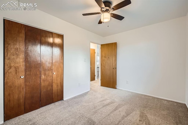 unfurnished bedroom with a ceiling fan, baseboards, light carpet, and a closet