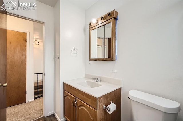 bathroom with vanity, wood finished floors, and toilet